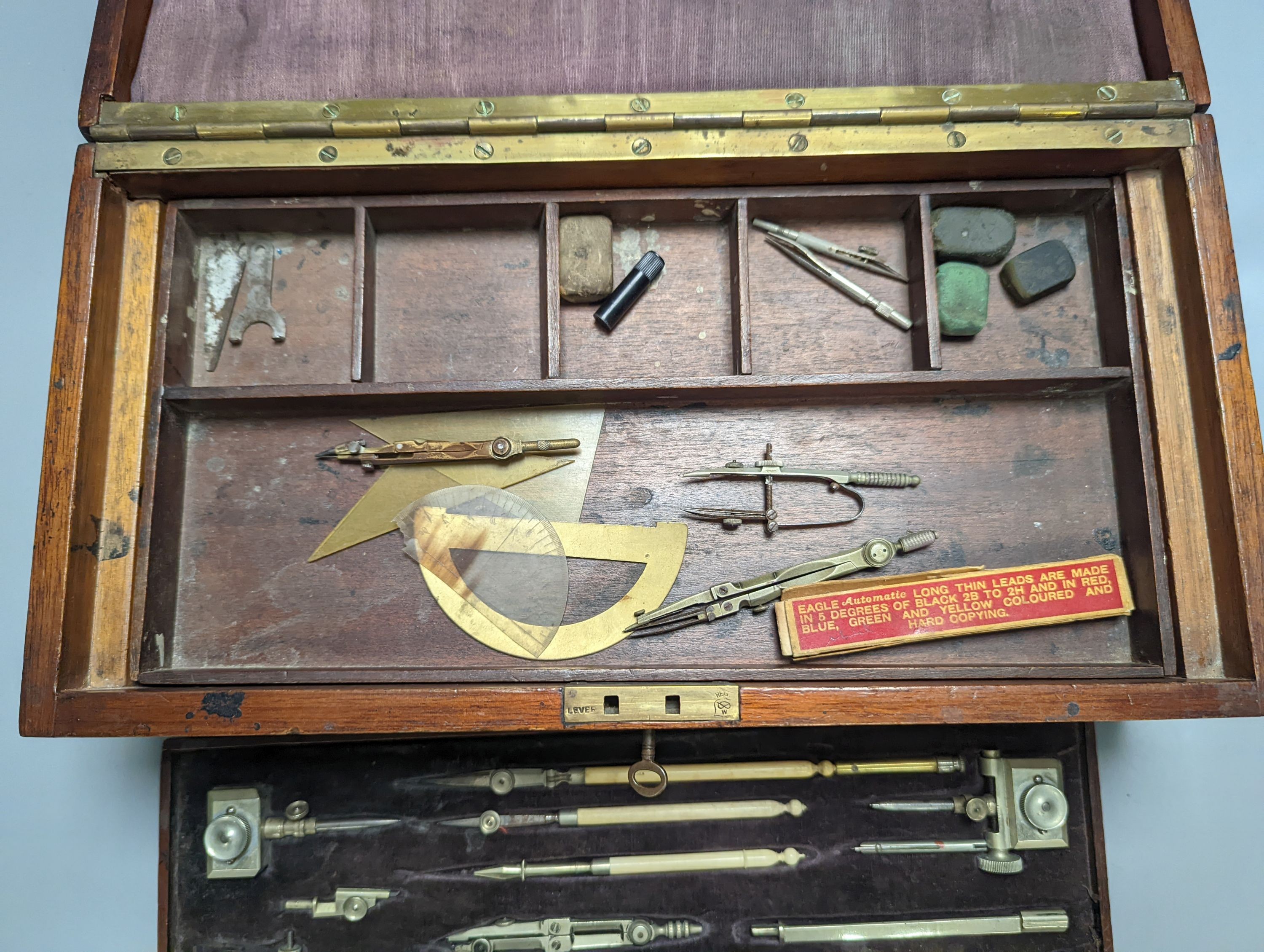 An early 20th century large mahogany case of electrum drawing instruments, wood squares and rulers, 37 x 18.5cm, incomplete